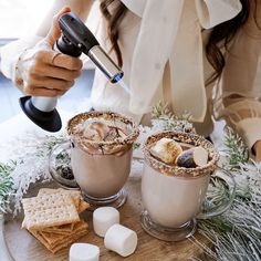 two cups of hot chocolate and marshmallows on a table