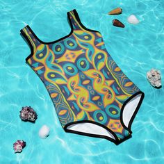 Dress your little trendsetter in retro charm with our Mid Century Modern Mosaic Girls Swimsuit (Size 2T-7), perfect for making a splash this summer. Featuring a vibrant mosaic design inspired by mid-century aesthetics, this swimsuit exudes playful elegance and style. Let your child stand out by the pool or beach in this must-have swimwear, offering both fashion and comfort for sizes 2T to 7. Retro Printed Swimwear For Beach Season, Multicolor Summer Swimwear For Play, Multicolor Graphic Print Swimwear For Beach Season, Multicolor Casual Swimwear For Summer, Playful Graphic Print Swimwear, Multicolor Retro Swimwear For Beach Season, Retro Print Swimwear For Summer Beach, Retro Print Swimwear For Beach In Summer, Retro Multicolor Swimwear For Beach Season