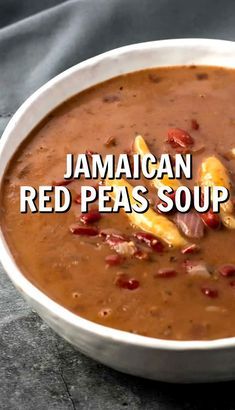 a white bowl filled with red pea soup on top of a black tablecloth and text that reads jamaican red peas soup