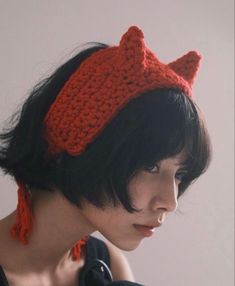 a close up of a person wearing a knitted hat with cat ears on it