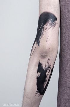 a man's arm with black and white ink splattered on the arm