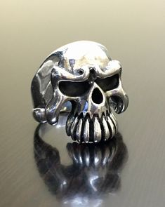 DeKara Designs Silver Metal- Sterling Silver, .925. Great looking handmade sterling silver heavy skull ring. RING IS ENTIRELY HANDMADE The ring has a black antique finish in the eyes, nose, and teeth, then finished with a beautiful high polish. This ring is really awesome! The ring is a size 8 3/4. FREE SIZING FREE SHIPPING 7 Day Return Policy, starting on the day you receive the earrings. Customer pays for the shipping back. I guarantee every single engagement ring, band, bracelet, earrings, pe Silver Skull Ring Collectible, Sterling Silver Skull Ring Collectible, Collectible Sterling Silver Skull Ring, Silver Biker Skull Ring For Biker Events, Biker Skull Ring For Biker Events, Engagement Ring Band, Handmade Skulls, Silver Skull Ring, Biker Rings