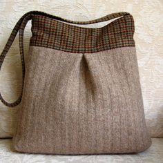 a handbag with a brown and tan checkered design on the front is sitting on a white couch