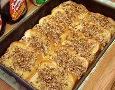 a pan filled with food sitting on top of a table next to cans of soda