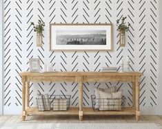 a wooden table sitting in front of a wall with black and white chevrons on it