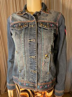 This western boho inspired denim jacket is made by Delila, in a size small.  It has so many great details, highlighted by the center back Indian Head applique.  Lots of embroidery, studs and rhinestones.  Original tags, never worn.  As is, no returns, sales final. Jacket With Embroidery, Embellished Denim Jacket, Retro Jeans, Indian Head, Embellished Denim, Western Boho, Rhinestone Studs, Jean Jackets, Dallas Tx