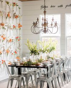 a dining room table with chairs and flowers on the wall