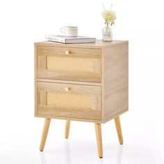 a small wooden table with two drawers and a coffee cup on top of the drawer