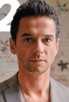 a close up of a person wearing a suit and necklace on the cover of a magazine