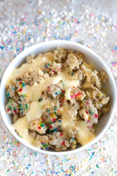 a bowl filled with ice cream and sprinkles on top of a table