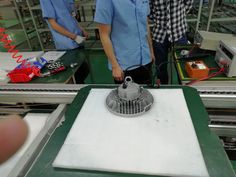 two men in blue shirts are working on an assembly line