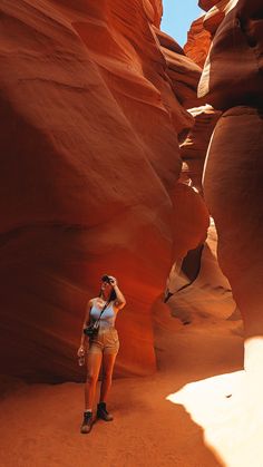 a woman standing in the middle of a canyon