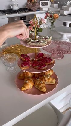 a table topped with three tiered plates filled with pastries