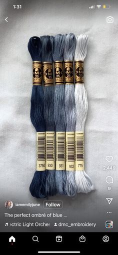 four skeins of blue and white yarn with gold trim on a white background