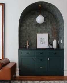 a living room with green cabinets and a brown chair