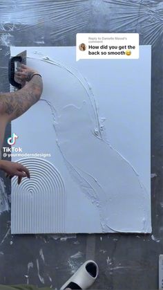 a man is painting on the wall with white paint