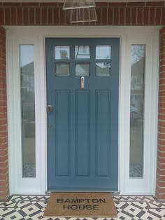 a blue front door with the words hampton house on it and a welcome mat in front