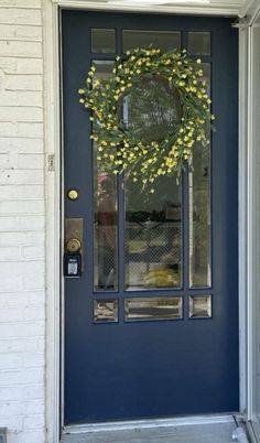 a blue front door with a wreath on it