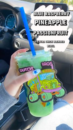 a person holding up a green drink in their hand with the words blue raspberry pineapple passonfruit on it