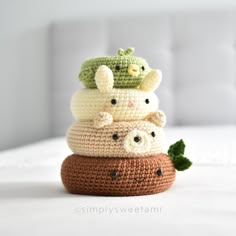 three crocheted stuffed animals are stacked on top of each other in the middle of a bed