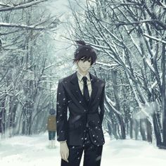 a man in a suit and tie standing in front of snow covered trees on a snowy day