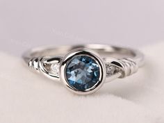 Welcome to my shop, you can find many beautiful gemstone jewelry here, and you also can ask for customized service.  Main Stone: Real London blue topaz , round cut 6 mm  Accent Stones: CZ Metal: 925 sterling silver plated with rhodium so as to protect the ring from tarnish and keep it shinning. I also can provide metal options such as 14k solid yellow/white/rose gold Setting: bezel setting  more rings: https://www.etsy.com/shop/XCjewelryStudio?ref=hdr_shop_menu It's quite comfortable for wearing Silver Rings For Women Stones, Ring With Blue Stone, Twisted Band Engagement Ring, Twist Engagement Ring, Meaningful Rings, Swiss Blue Topaz Ring, November Birthstone Ring, Engagement Rings Twisted, Bezel Engagement Ring