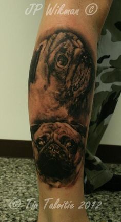 a man's leg with a tattoo of two dogs on the side of his leg