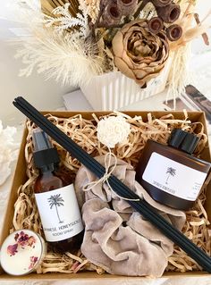 the gift box contains two bottles of essential oils and an assortment of flowers in it