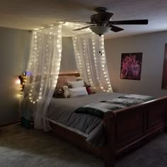 a bedroom with lights on the ceiling and a bed in front of a window that has curtains over it