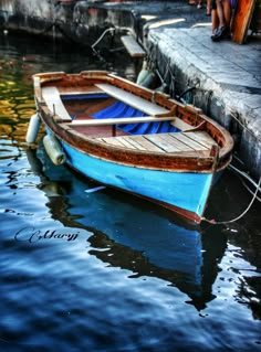 a small blue boat sitting in the water