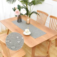 a wooden table topped with a vase filled with flowers next to a plate and cup