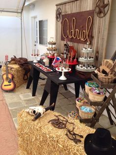 an outdoor birthday party with hay bales and decorations on the table, including a sign that reads western party birthday party ideas