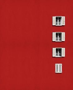 four windows on the side of a red building