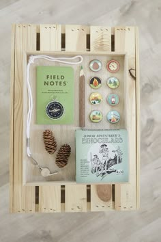 a wooden crate with pine cones, books and other items