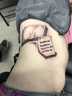 a woman with a book tattoo on her stomach