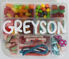 a plastic container filled with lots of candy and candies next to the word greyson