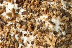 a close up view of a dessert with nuts and cream on it's surface