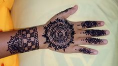 a woman's hand with henna tattoos on it