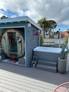 an outdoor hot tub on a deck next to a potted plant