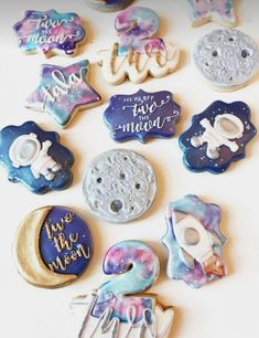 there are many decorated cookies in the shape of stars and moon on this white surface