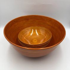 three wooden bowls stacked on top of each other in front of a white background,