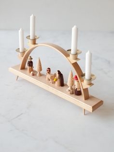 a wooden candle holder with candles and figurines on it