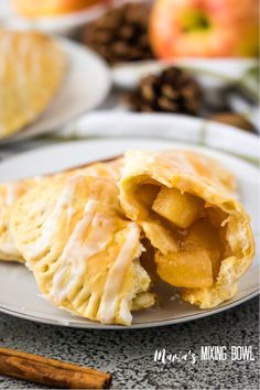 an apple turnover on a plate with cinnamon sticks