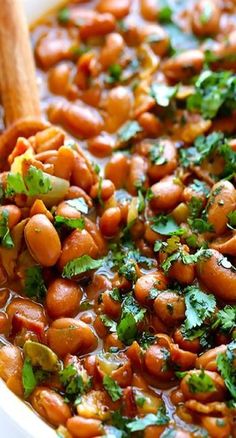 a white bowl filled with beans and cilantro