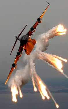 an airplane flying through the air with fire coming out of it's back end