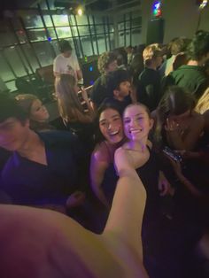 two women are hugging each other in the middle of a room full of people at a party