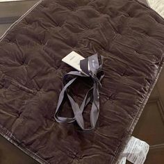 a brown mattress with a gray ribbon tied around the edge and tag on it's side