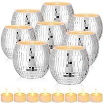 a set of six silver disco ball tea light holders with candles in front of them