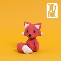 a small toy fox sitting on top of a yellow background with the words totoi frutt above it