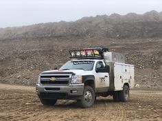 a white truck driving down a dirt road